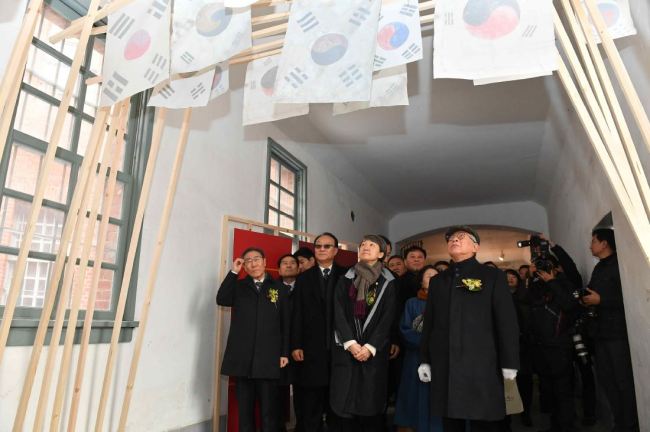 A group of visitors including Chung Jae-suk (first row, second from right), the chief of the Cultural Heritage Administration, take a look around the exhibition “100 Years of History Preserved in Cultural Heritage” at the Seodaemun Prison History Museum in Seoul in this Feb. 18 file photo. / Yonhap