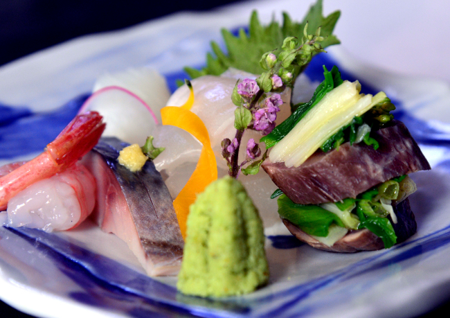 Sazanka’s sashimi is artistically plated with a colorful sprig of purple shiso flowers. (Park Hyun-koo/The Korea Herald)