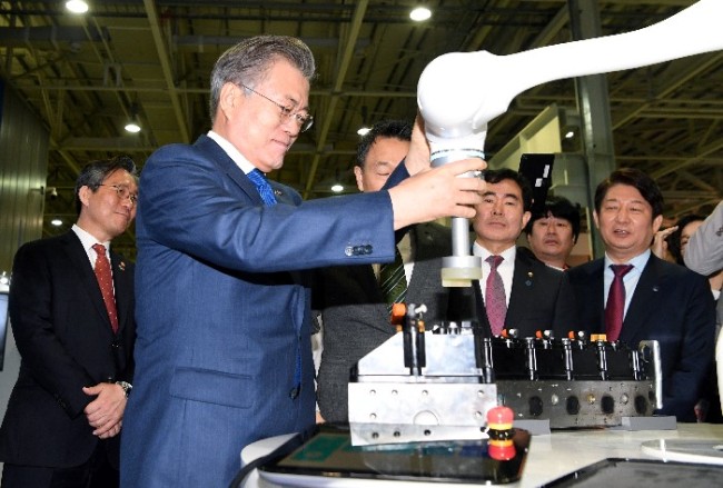President Moon Jae-in demonstrates a robot at the headquarters of Hyundai Robotics in Daegu City on Friday. (Yonhap)