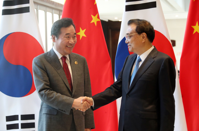 South Korean Prime Minister Lee Nak-yon shakes hands with Chinese Premier Li Kequiang ahead of the annual Boao Forum, held in southern island province of Hainan. (Yonhap)
