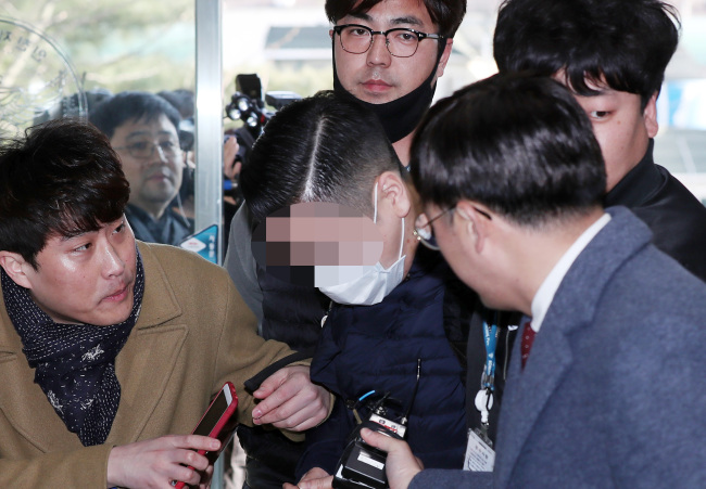 Wearing a face mask, a grandson of SK Group founder appears at a police station on Monday, after he was arrested for allegedly purchasing liquid marijuana. (Yonhap)