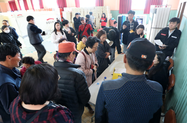 Volunteers distribute relief supplies to victims who lost their houses to fire. (Yonhap)