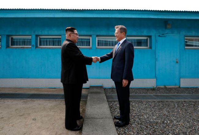 South Korean President Moon Jae-in (right) and North Korean leader Kim Jong-un shake hands at the peace village of Panmunjom on April 27, 2018. (Yonhap)