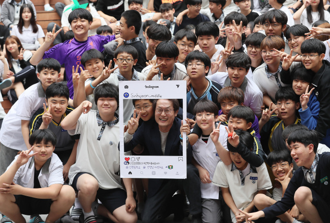 Cho Hee-yeon, Seoul’s education superintendent, poses with middle school students Wednesday. (Yonhap)