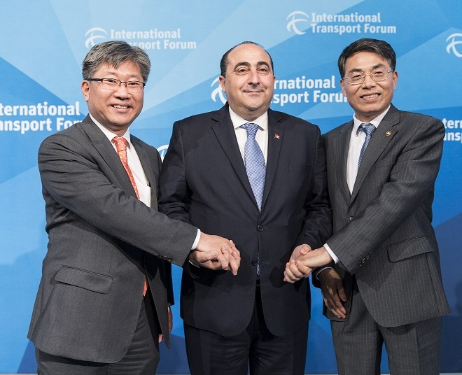 International Transport Forum Secretary-General Kim Young-tae (left) and Vice Transport Minister Kim Jeong-ryeol of South Korea (right) shake hands with Tunisian Transport Minister Hichem Ben Ahmed at the ITF summit in Leipzig, Germany, Thursday, welcoming the African country as the forum’s 60th member. (ITF)