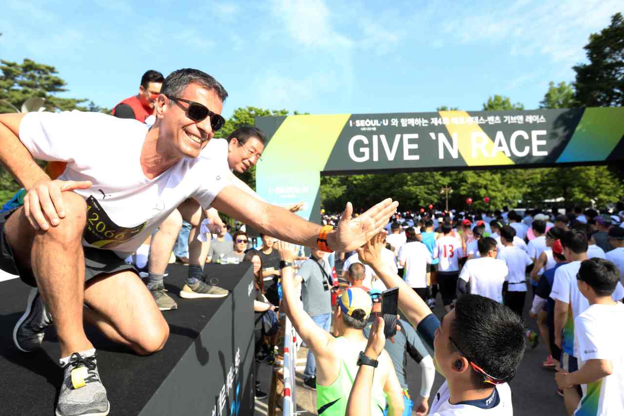Mercedes-Benz Korea CEO and CSR Committee Chairman Dimitris Psillakis (left) and Seoul Mayor Park Won-soon (center) encourage runners during “Give ’n Race,” a charity marathon co-hosted by the city government and the local unit of the German carmaker, in Seoul on Sunday. (Mercedes-Benz Korea)