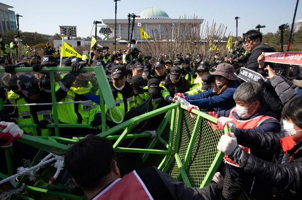 Members of the Korean Confederation of Trade Unions try to push their way into the National Assembly on April 3 in protest against the revision of flexible working hours and the minimum wage law. (Yonhap)