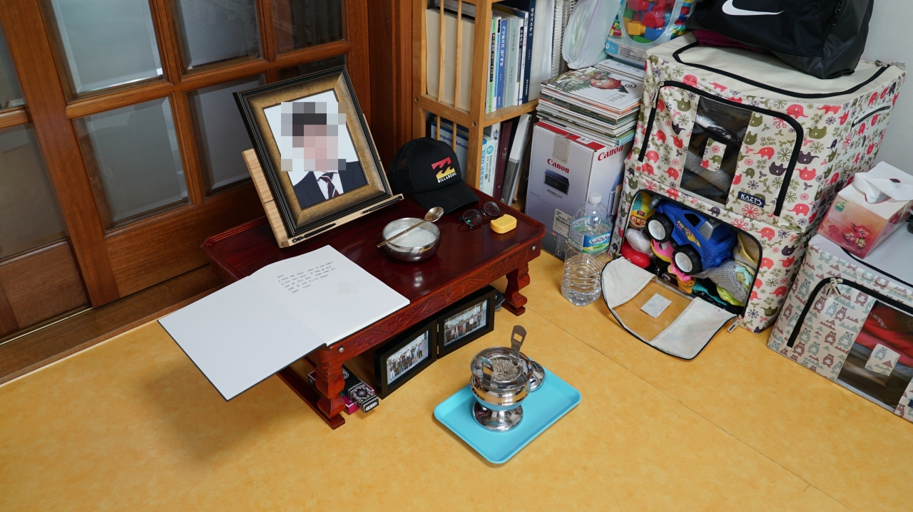 An altar for the alleged murder victim is set up at the home where he lived with his family. On the right are boxes where he kept his son’s old toys and clothes. (Kim Arin/The Korea Herald)
