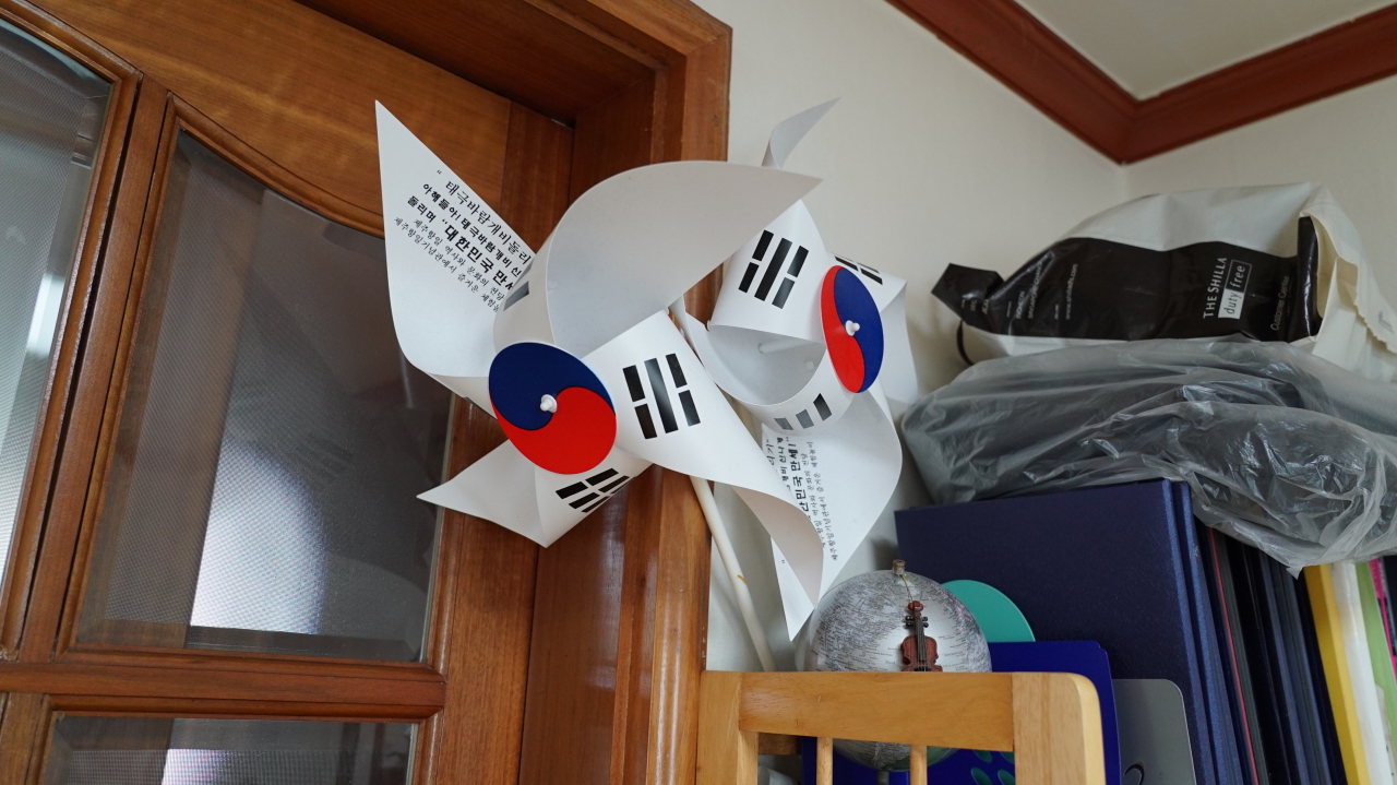 On the top shelf of a bookcase in a corner of the victim’s room are paper pinwheels with the Korean flag that the victim had made for his son. (Kim Arin/The Korea Herald)