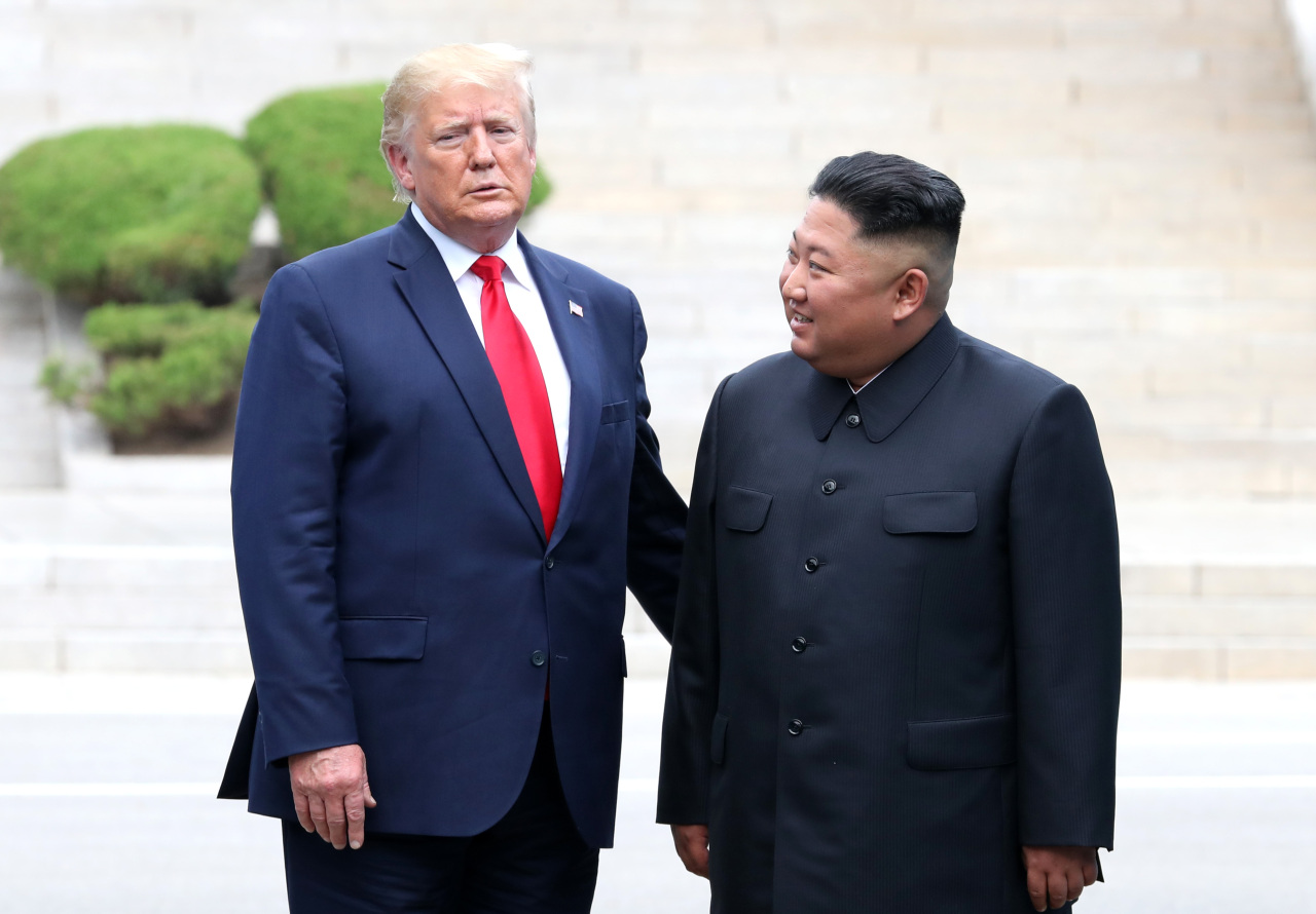 US President Donald Trump and North Korean leader Kim Jong-un pose on the North Korean side of the Military Demarcation Line on Sunday. Yonhap