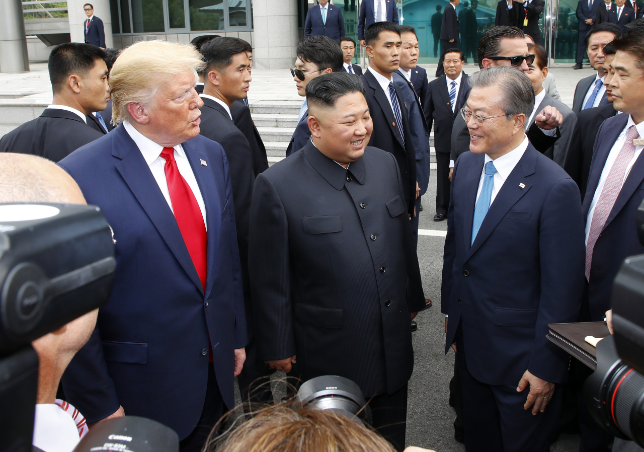 President Moon Jae-in, US President Donald Trump and North Korean leader Kim Jong-un exchange words outside the Freedom House on the South Korean side of Panmunjom on Sunday. Yonhap