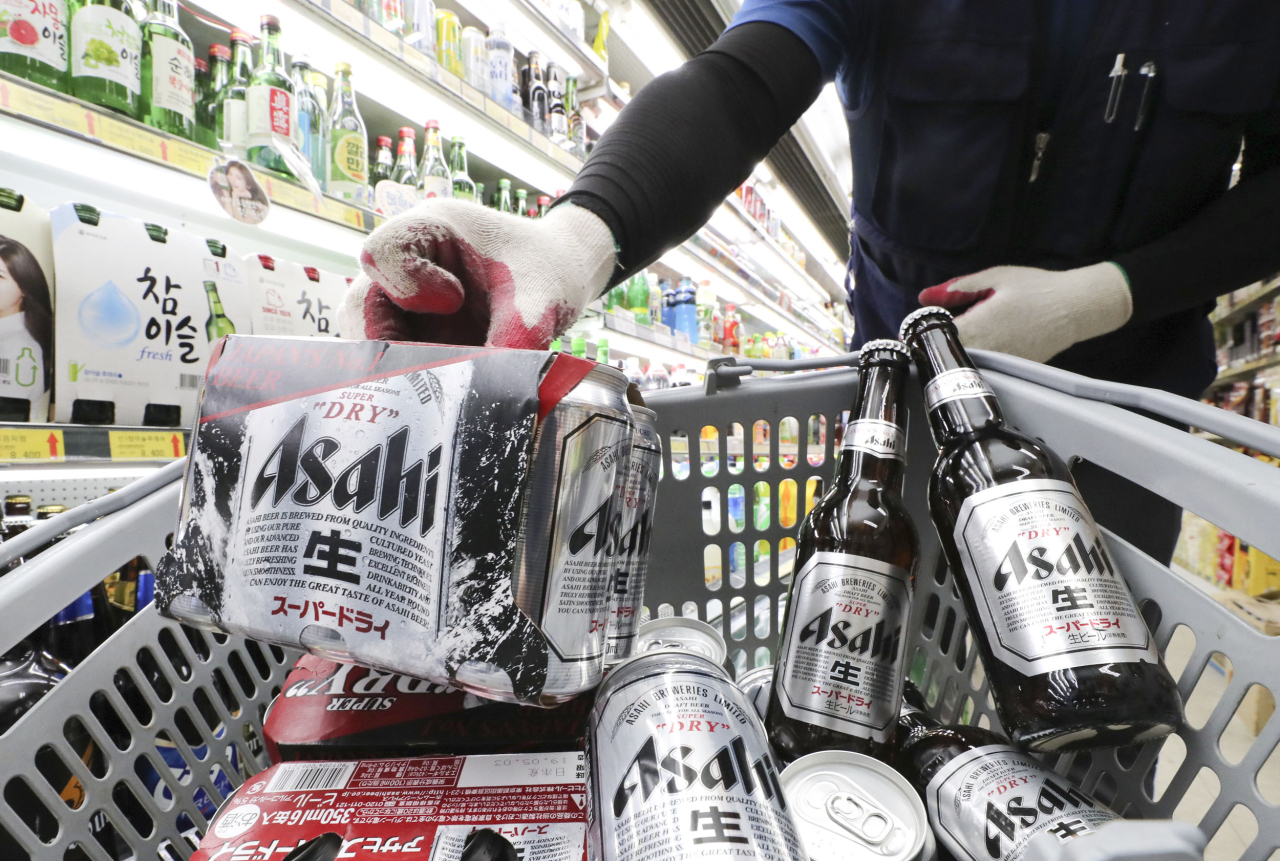 Supermarket staff unrack Japanese beer brand Asahi from shelves at a store in Seoul. (Yonhap)