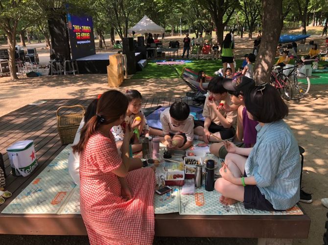 Participants of a picnic organized by Greenpeace’s Seoul office enjoy food prepared without any single-use items, at Seoul Forest on July 6. (Ock Hyun-ju/The Korea Herald)