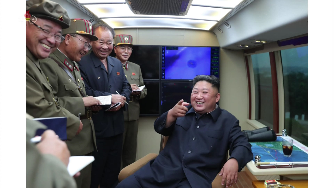 North Korean leader Kim Jong-un smiles as he guides the test-firing of a 