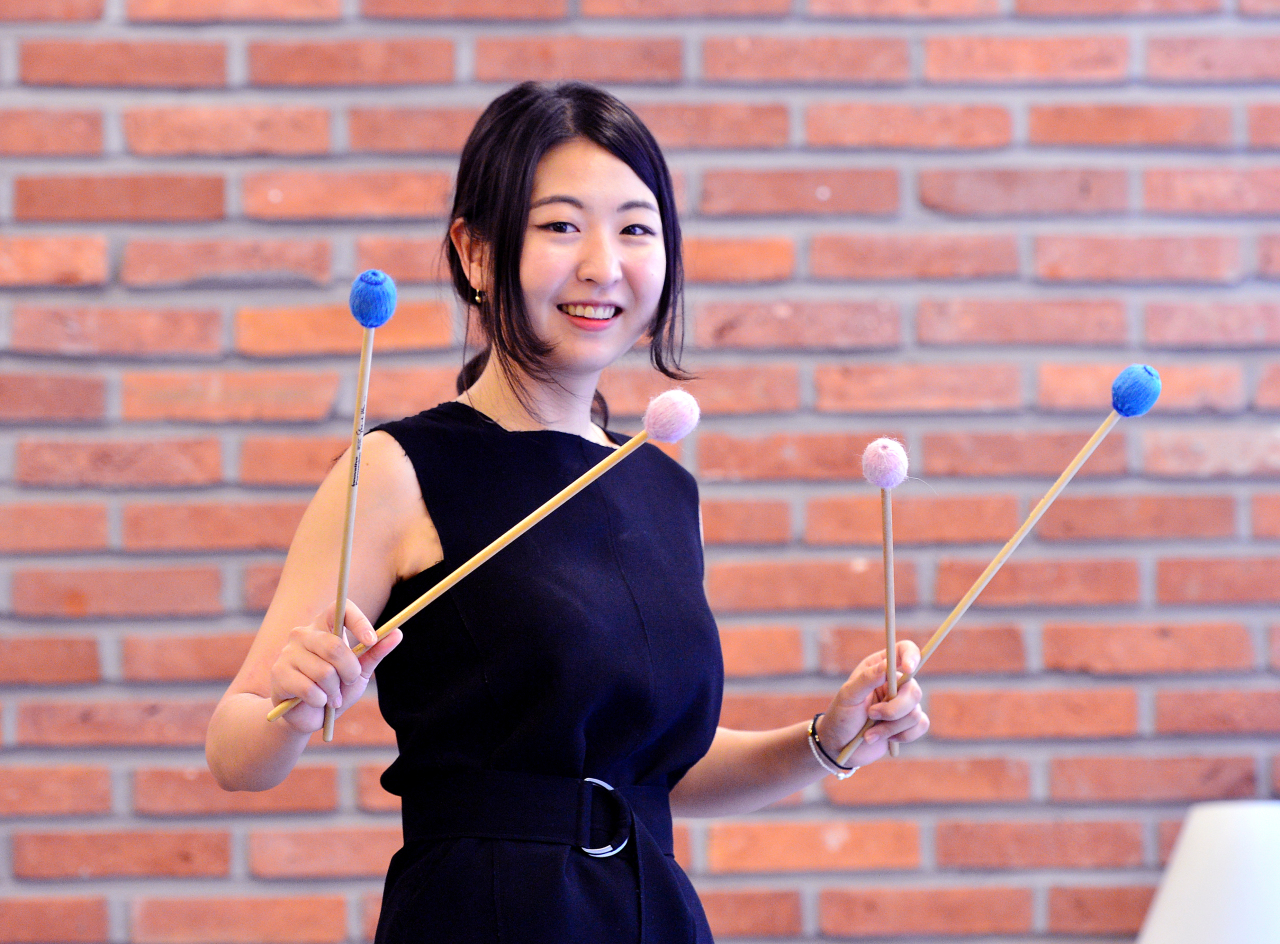 Percussionist Lee Hyun-gi poses for photos with her marimba mallets before an interview with The Korea Herald on Monday. (Park Hyun-koo / The Korea Herald)