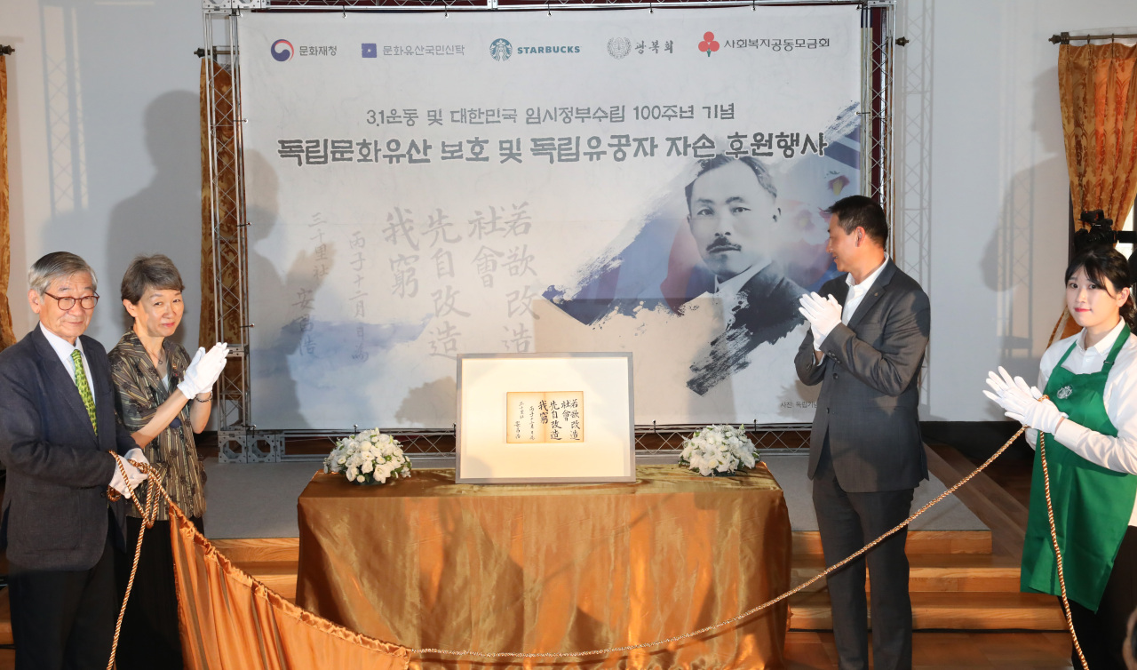 From left: National Trust for Cultural Heritage Chairman Kim Jong-kyu, Cultural Heritage Administration head Chung Jae-suk and Starbucks Coffee Korea CEO Song Ho-seob participate in an unveiling ceremony in Deoksugung Palace on Tuesday. (Starbucks Coffee Korea)