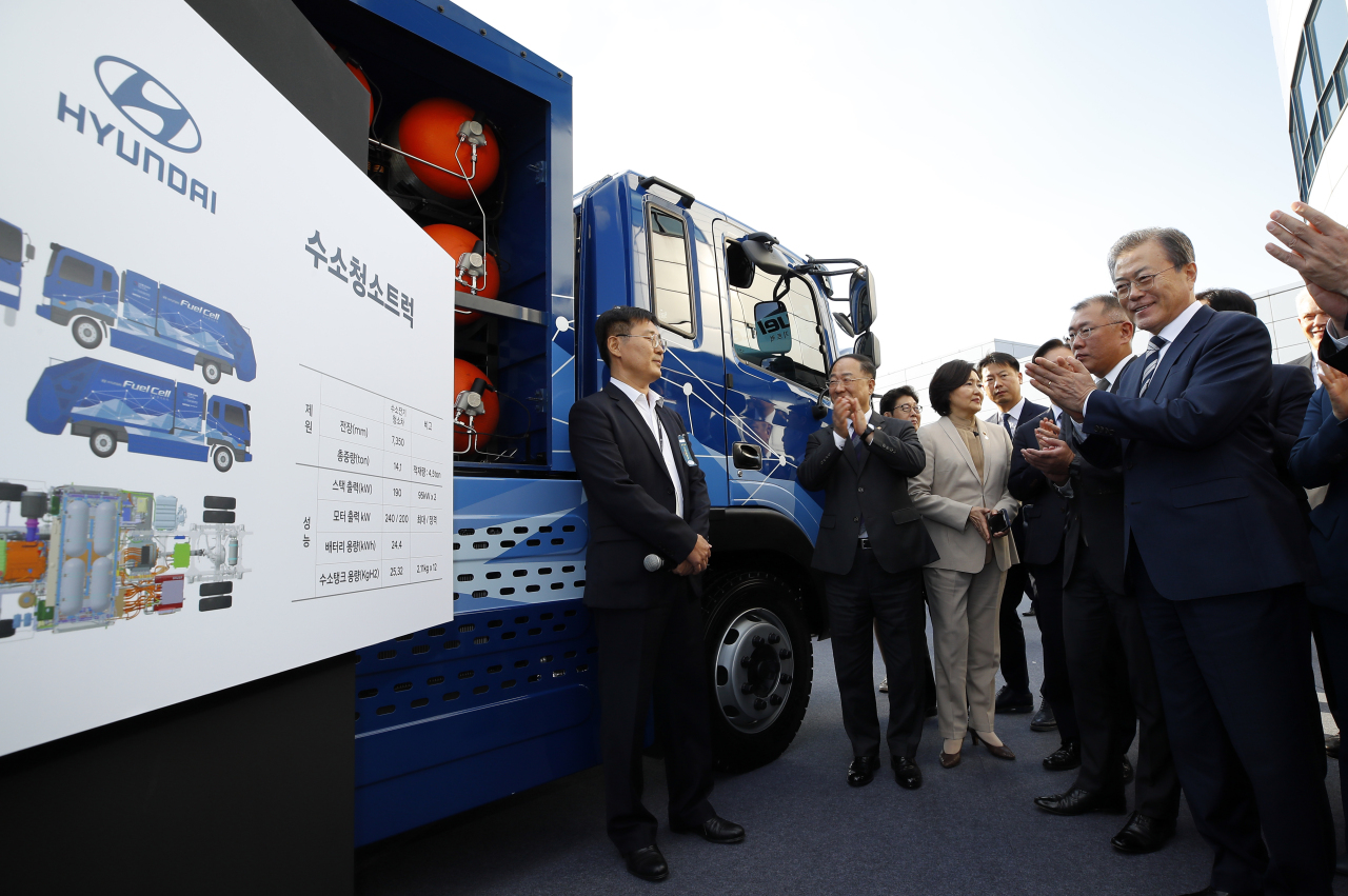 President Moon Jae-in (third from right) is briefed by an official from Hyundai Motor about a hydrogen-powered garbage truck during his visit to the carmaker's Namyang R&D Center in Hwaseong, Gyeonggi Province, Tuesday. Frouth from right Hyundai Motor's executivee vice chairmain Chung Euisun. (Yonhap)
