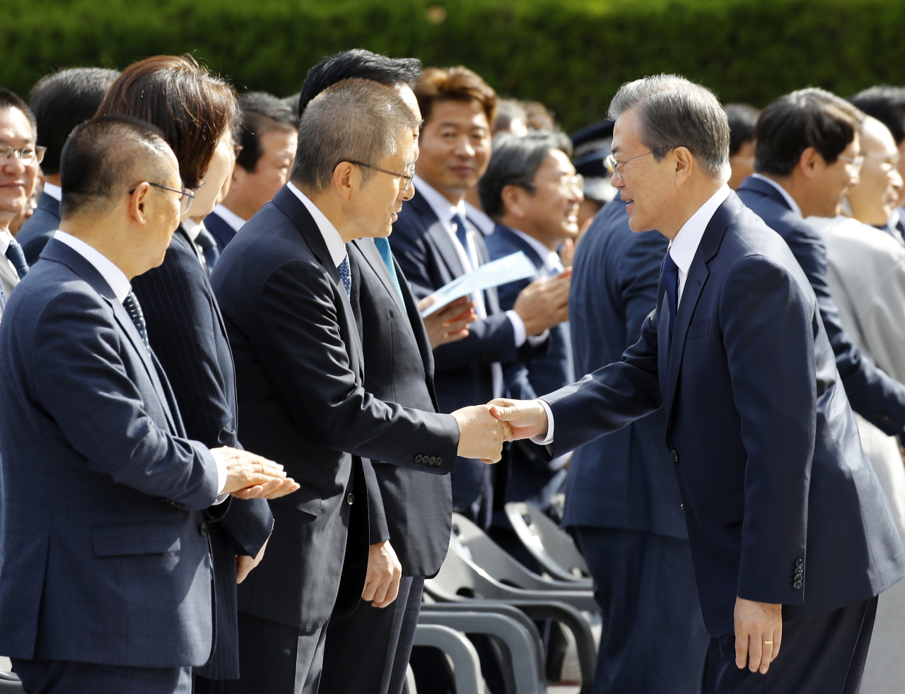 President Moon Jae-in shakes hands with Hwang Kyo-ahn, chairman of main opposition Liberty Korea Party, at the Busan-Masan Democratic Protests event in Busan on Wednesday. Yonhap