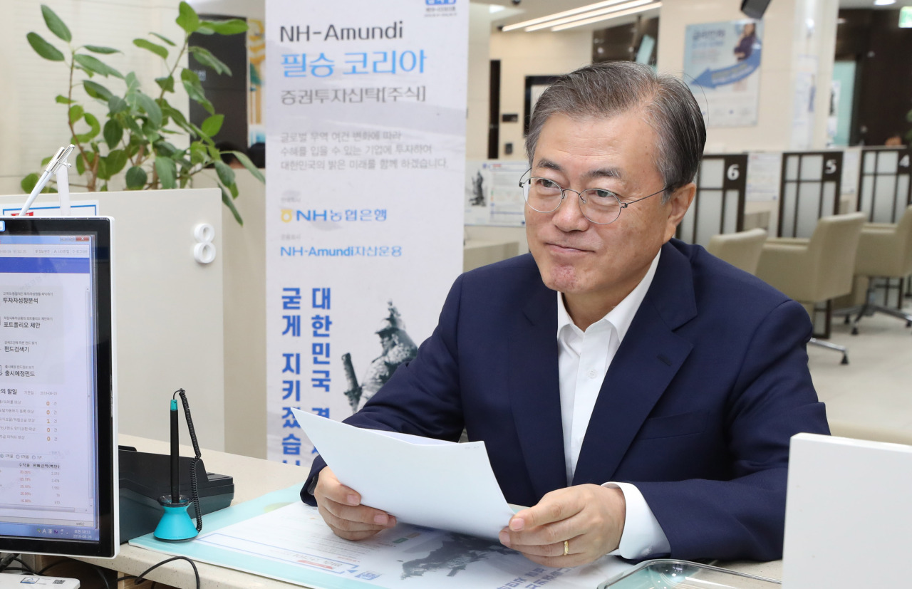 President Moon Jae-in visits the NH NongHyup headquarters in August to sign in NH-Amundi Victorious Korea Equity Fund. (Yonhap)