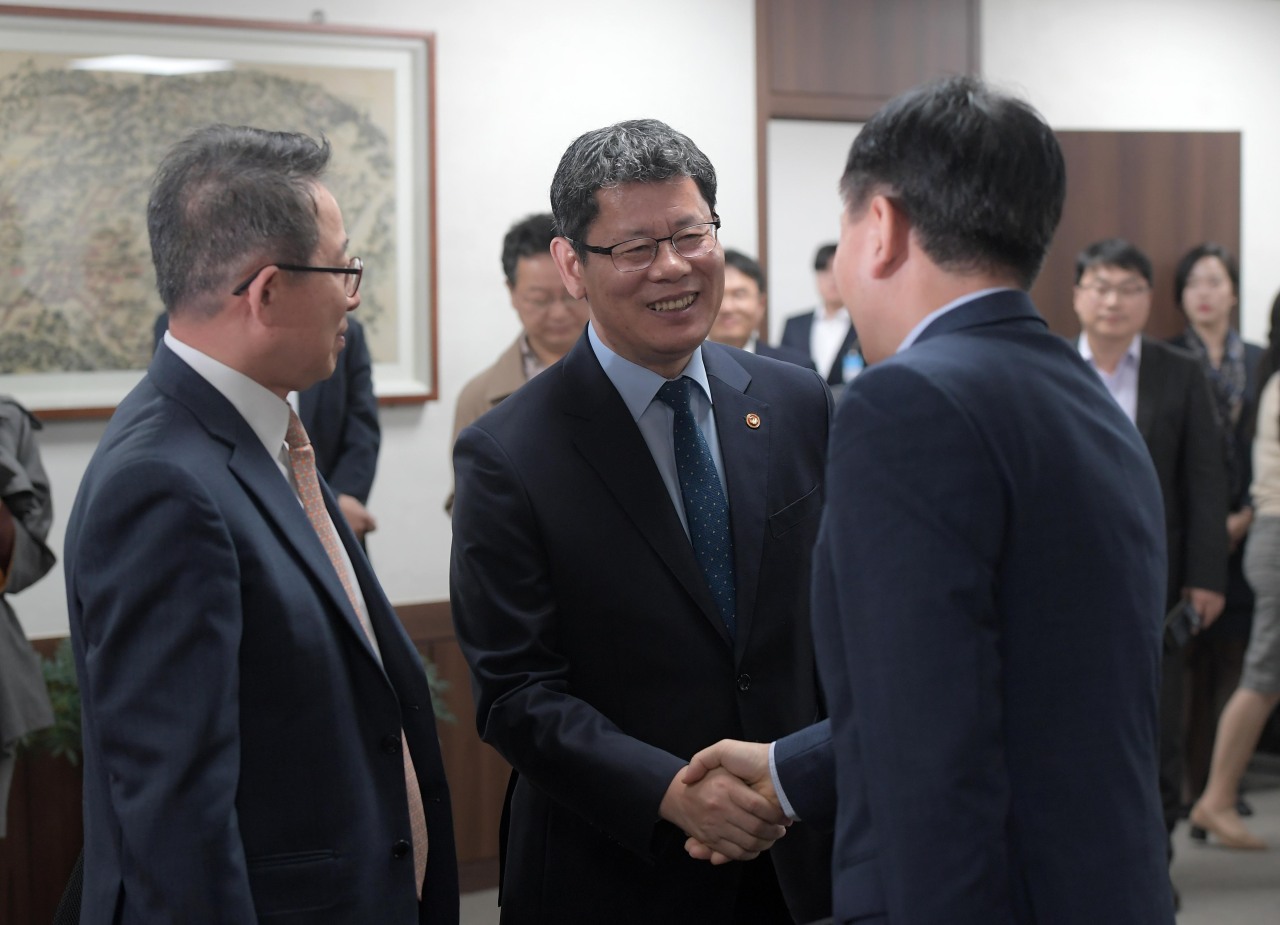Unification Minister Kim Yeon-chul (center) shakes hands with Bae Kook-hwan (left), president of Hyundai Asan, and Ahn Young-bae, president of the Korean Tourism Organization at the Ministry of Unification in Seoul. (Yonhap)
