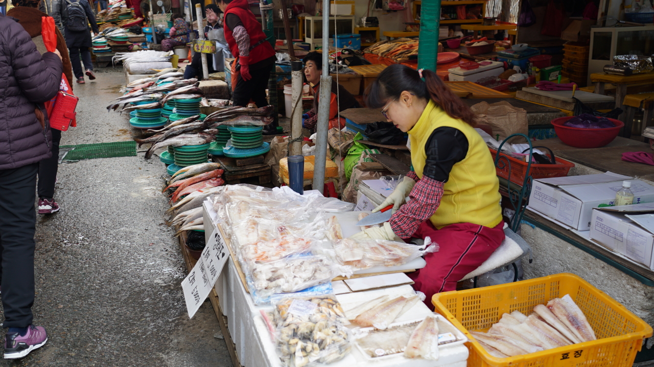 A woman slices up a pollack at Jagalchi Market in Busan. (Yoon Min-sik/The Korea Herald)