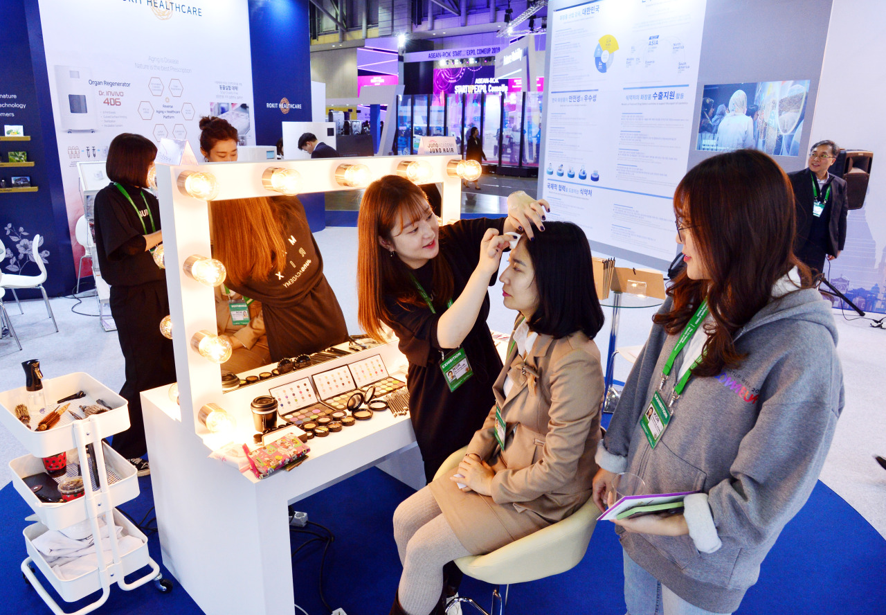 A visitor at the K-beauty Festival receives makeup at BEXCO on Monday. (Park Hyun-koo / The Korea Herald)