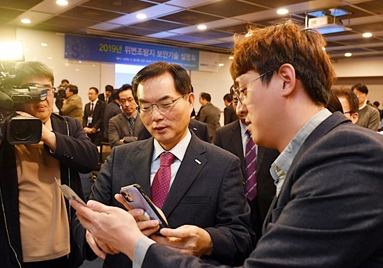Komsco CEO Cho Yong-man (left) watches a demonstration for the company’s 