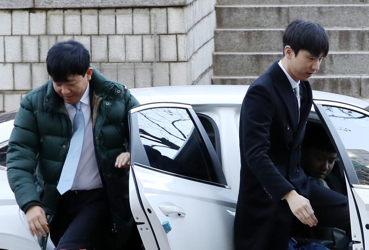Lee Jae-woong (left), CEO of car-sharing company SoCar which owns the operator van-hailing service Tada, and VCNC CEO Park Jae-wook (right) arrive at Seoul Central District Court on Monday. (Yonhap)