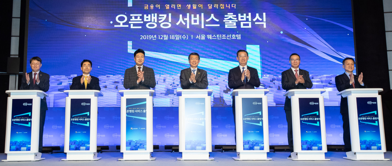 Financial Services Commission Chairman Eun Sung-soo (fourth from left), Korea Financial Telecommunications and Clearings Institute President Kim Hak-soo (sixth from left) and other participants attend a ceremony marking the launch of the open banking service on Wednesday in Seoul. (FSC)