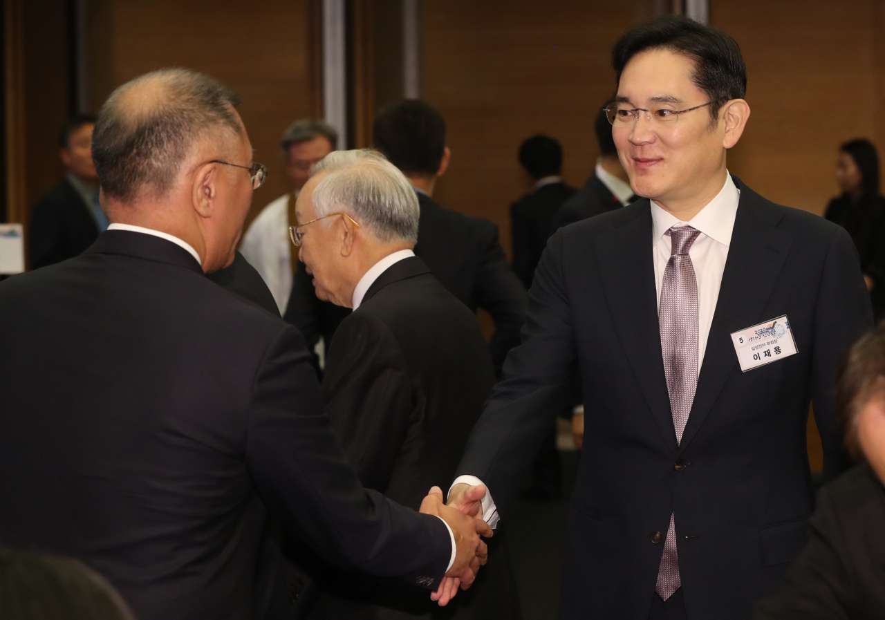 Lee Jae-yong (right) shakes hands with Hyundai Motor Executive Vice Chairman Chung Euisun at a New Year’s luncheon of corporate and government officials, held on Thursday at the Korea Chamber of Commerce and Industry in central Seoul. (Yonhap)