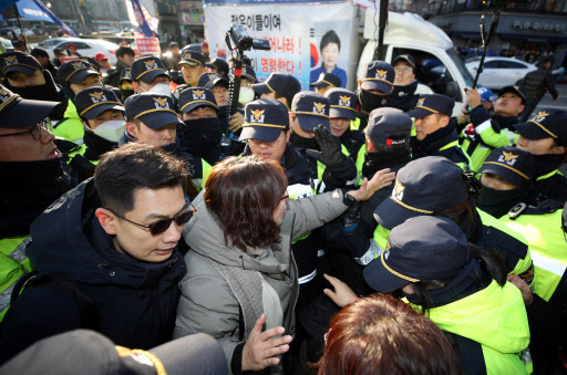 Families of students of the Seoul National School for the Blind are stopped by police officers as they hold a rally condemning “excessive rallies” that violate students’ right to learn and move near the presidential office, on Jan. 4. (Yonhap)