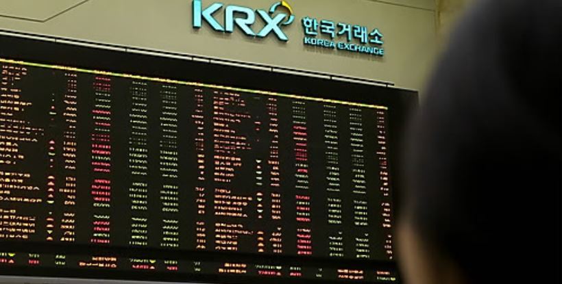An investor monitors share prices on an electronic board at the Korea Exchange. (Yonhap)