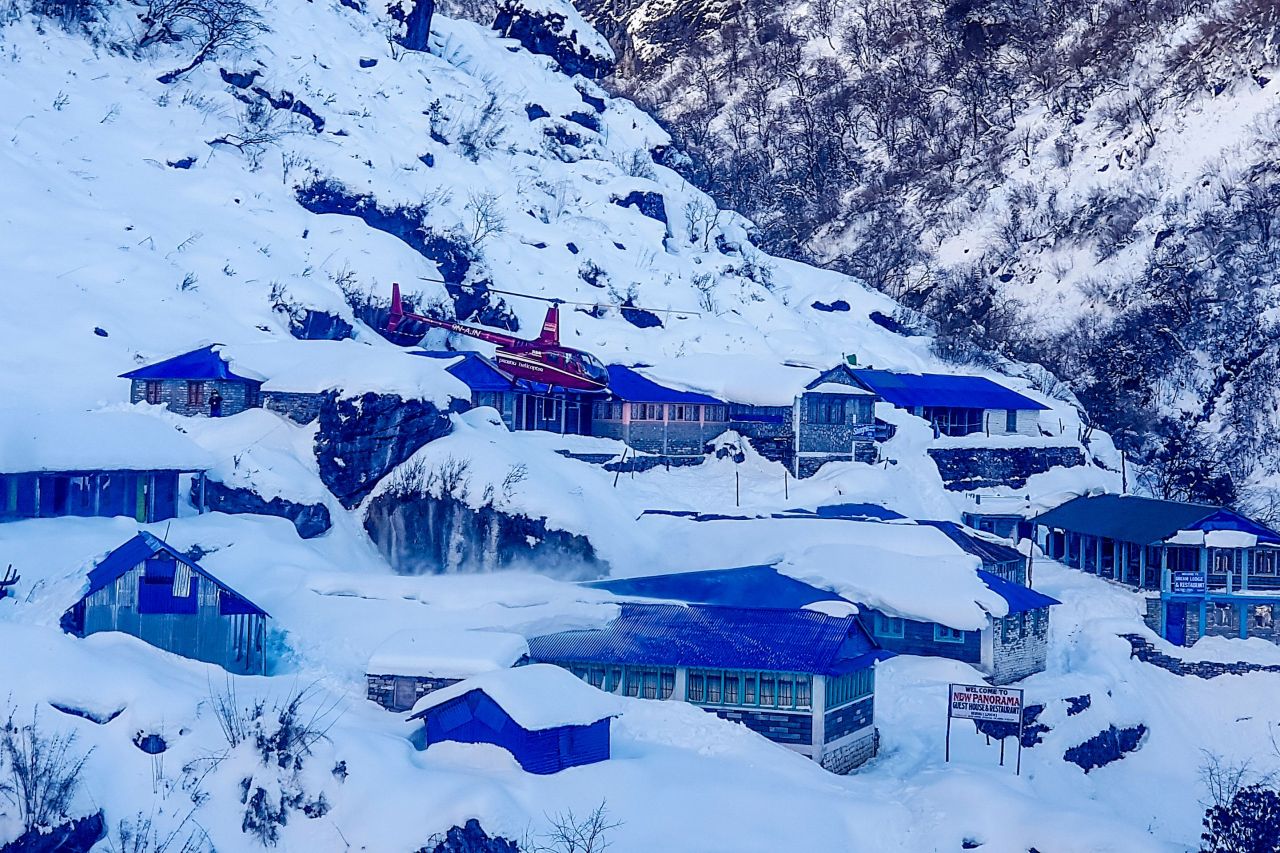 A helicopter flies over Deurali near the avalanche site in Annapurna mountain region, some 200 kms west of Kathmandu Monday - Rescuers intensified search efforts on January 20 for four South Koreans and three Nepalis caught in an avalanche in the popular Annapurna region of the Himalayas, officials said, with teams hoping to dig through snow to find them. (EPA-Yonhap)