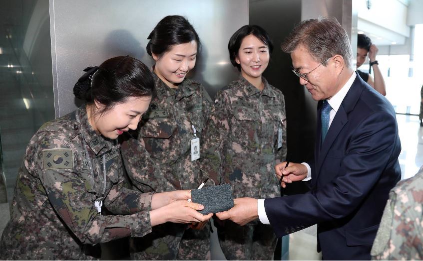 President Moon Jae-in gives his autograph to soldiers during his visit to the Ministry of National Defense in Seoul on May 17, 2017. The administration has promised to slash the Army service term for draftees by three months to 18 months. (Cheong Wa Dae Press Corps)