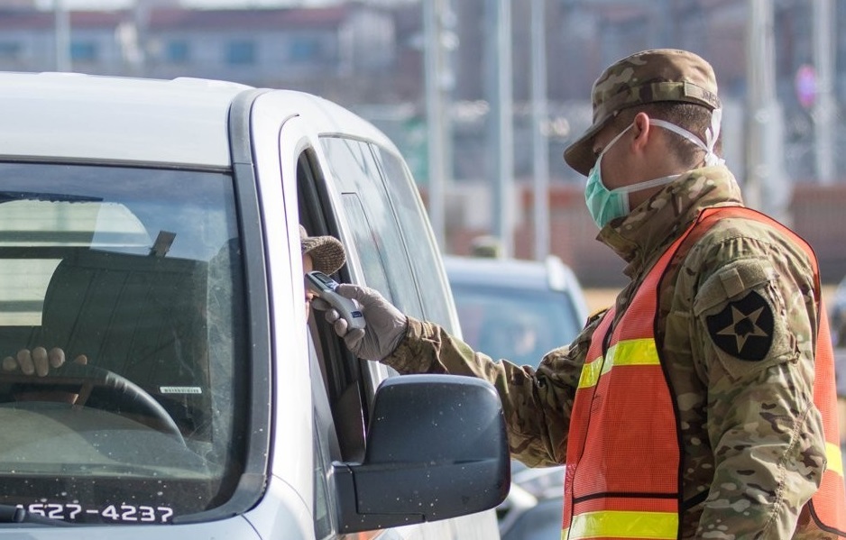 A military guard at US Army Garrison Humphreys in Pyeongtaek, 70 kilometers south of Seoul, checks the temperature of a driver to screen entrants to the compound for the novel coronavirus on Feb. 28, 2020, in the photo provided by United States Forces Korea. (PHOTO NOT FOR SALE) (Yonhap)