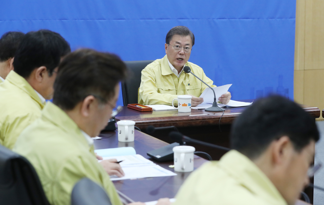 President Moon Jae-in holds a meeting with government officials and heads of local governments on the COVID-19 outbreak on Monday. Yonhap