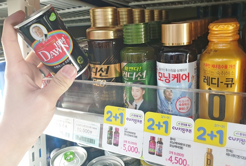 A customer picks up a hangover cure product at a convenience store. (CU)
