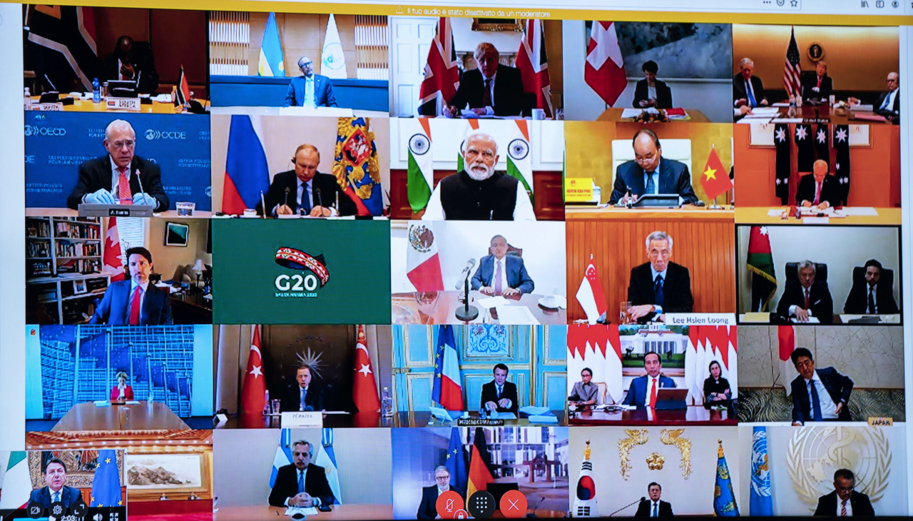 This photo of a television screen taken and handout by the press office of Palazzo Chigi on March 26, 2020 shows Italian Prime Minister, Giuseppe Conte (Bottom L) taking part in a video conference as part of an extraordinary meeting of G20 leaders, from the Chigi Palace in Rome, during the country's lockdown following the COVID-19 new coronavirus pandemic. (AFP-Yonhap)