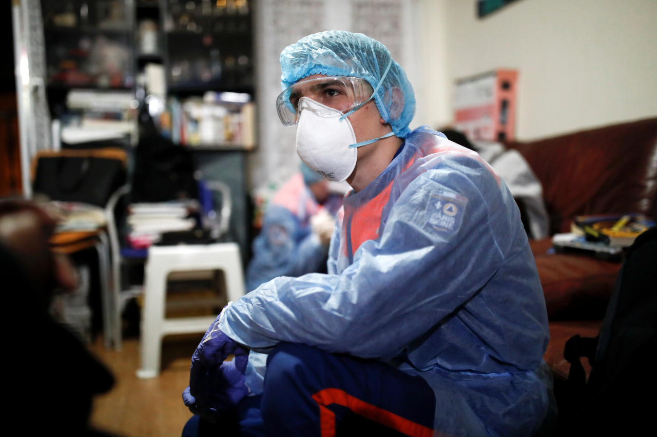 A member of the French Civil Protection service talks with the mother of a 18 year-old woman (not pictured) suspected of being infected with the coronavirus disease as its spread continues, in Paris on Saturday. (Yonhap)