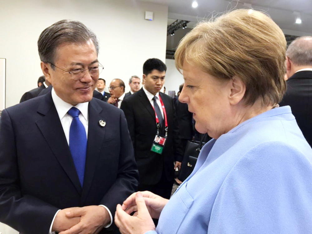 2019년 일본 오사카에서 열린 G20 정상회의에서 대화하는 문재인(왼쪽) 대통령과 메르켈 총리(연합뉴스)