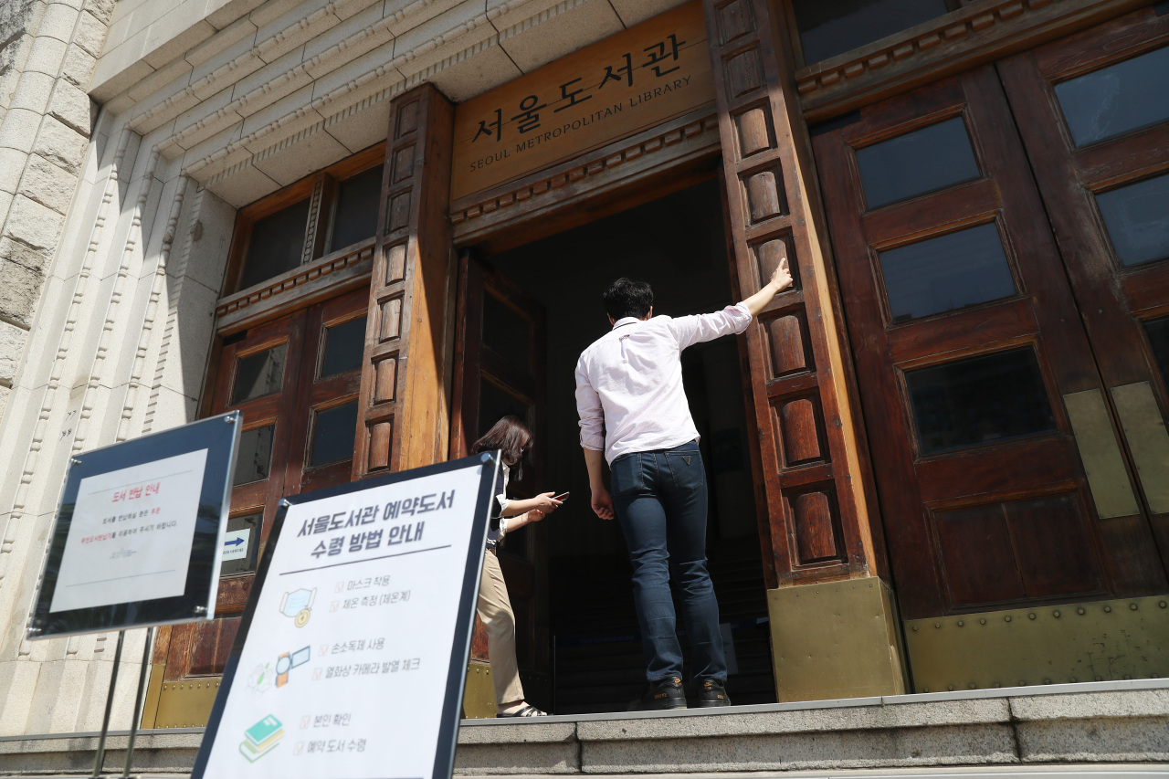Employees in Seoul on Wednesday prepare to open a public library that has been closed due to the novel coronavirus pandemic. Korea is starting an “everyday life quarantine” scheme for the normalization of schools and public facilities. (Yonhap)