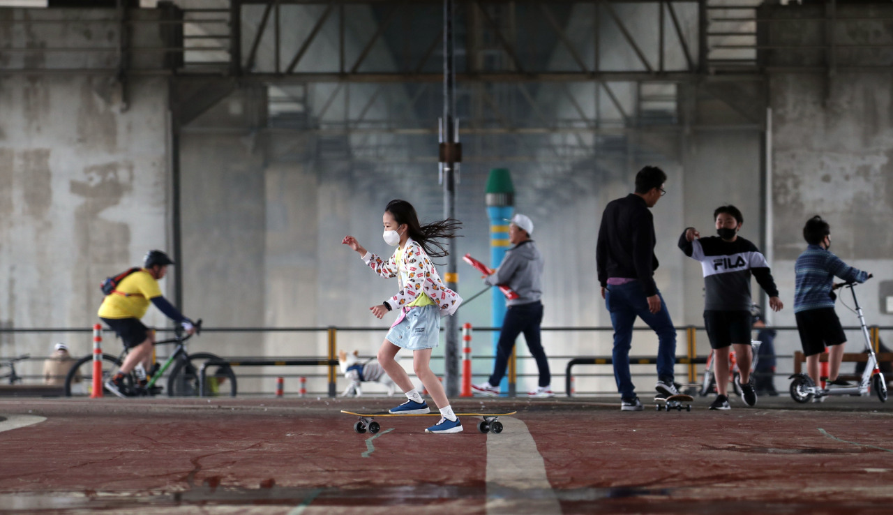 Children wear face masks at a riverside park in Yeouido, central Seoul. (Yonhap)