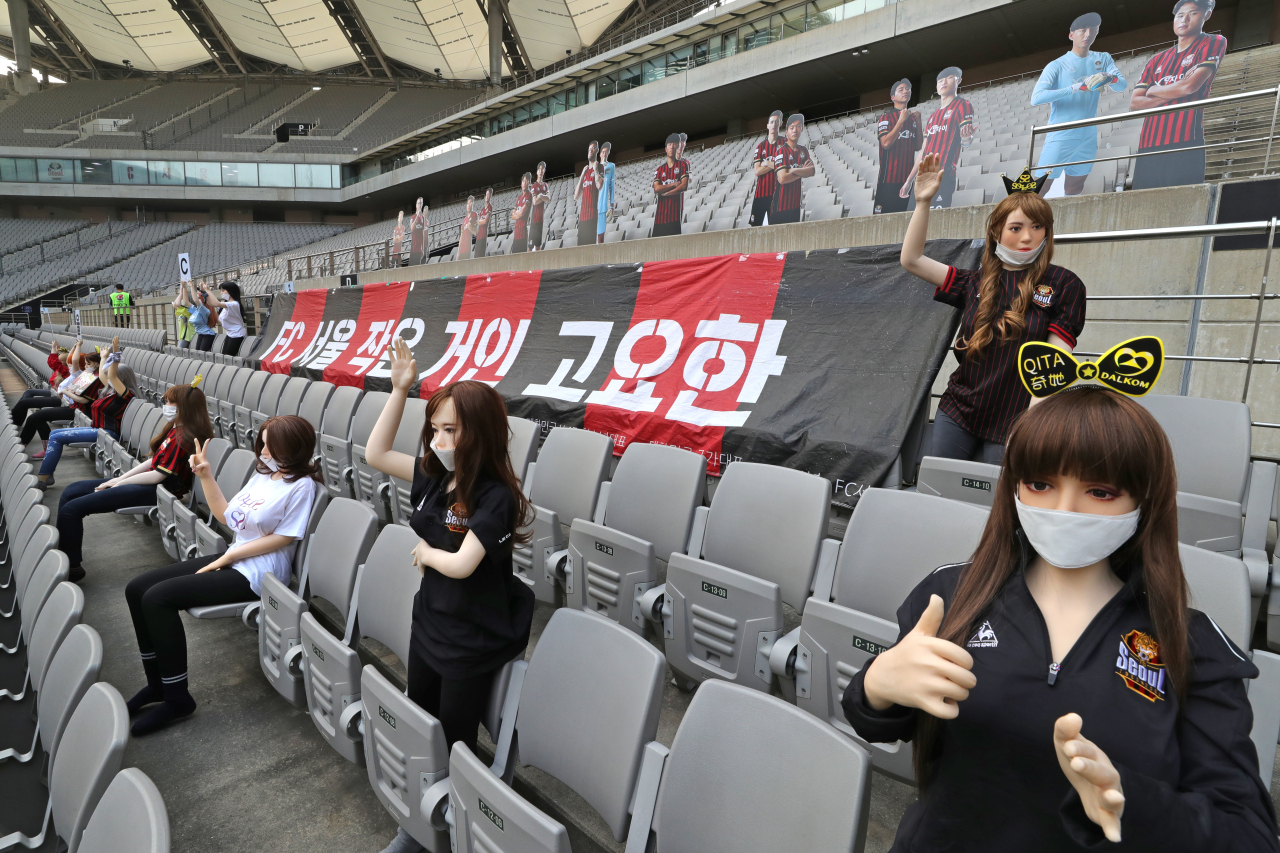 Alleged sex dolls holding up FC Seoul cheer signs are placed in the stand of Seoul World Cup Stadium on Sunday. (Yonhap)