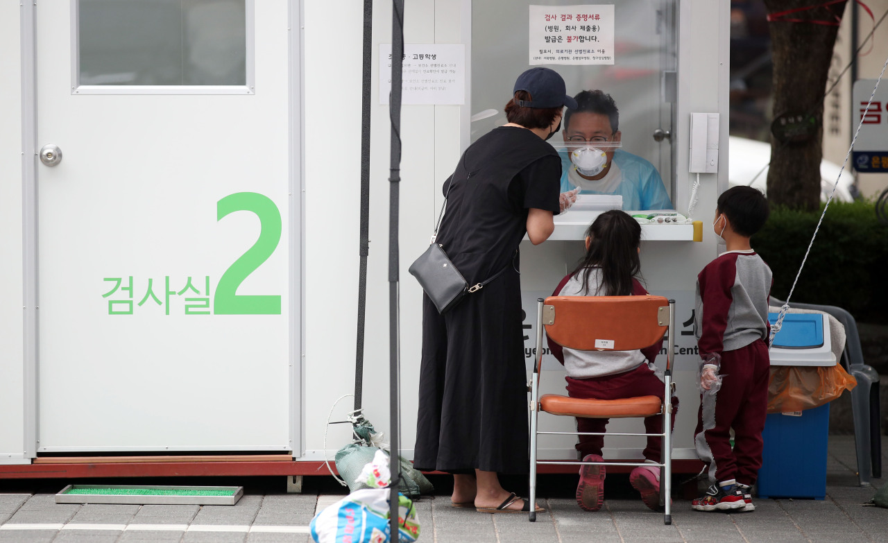 Two children visit coronavirus testing booth in Eunpyeong, northwestern Seoul, on Tuesday afternoon. (Yonhap)