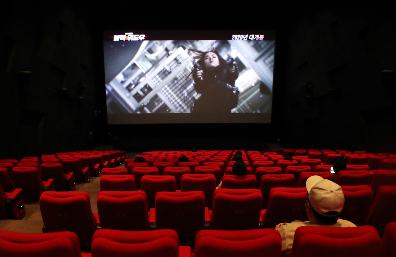 People sit far apart from each other in a mostly empty theater in Busan on May 6, practicing social distancing. (Yonhap)