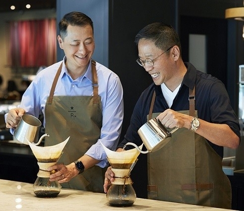 Hyundai Card Vice Chairman and CEO Chung Tae-young (right) and Starbucks Korea CEO Song Ho-seob brew coffee at Starbucks’ Jongno R branch in Seoul on Monday. (Hyundai Card)