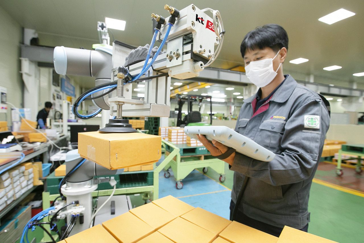 A Parkwon employee demonstrates semiautomated manufacturing process enabled by KT’s automated robotic solution Cobot in Jecheon, North Chungcheong Province. (KT)