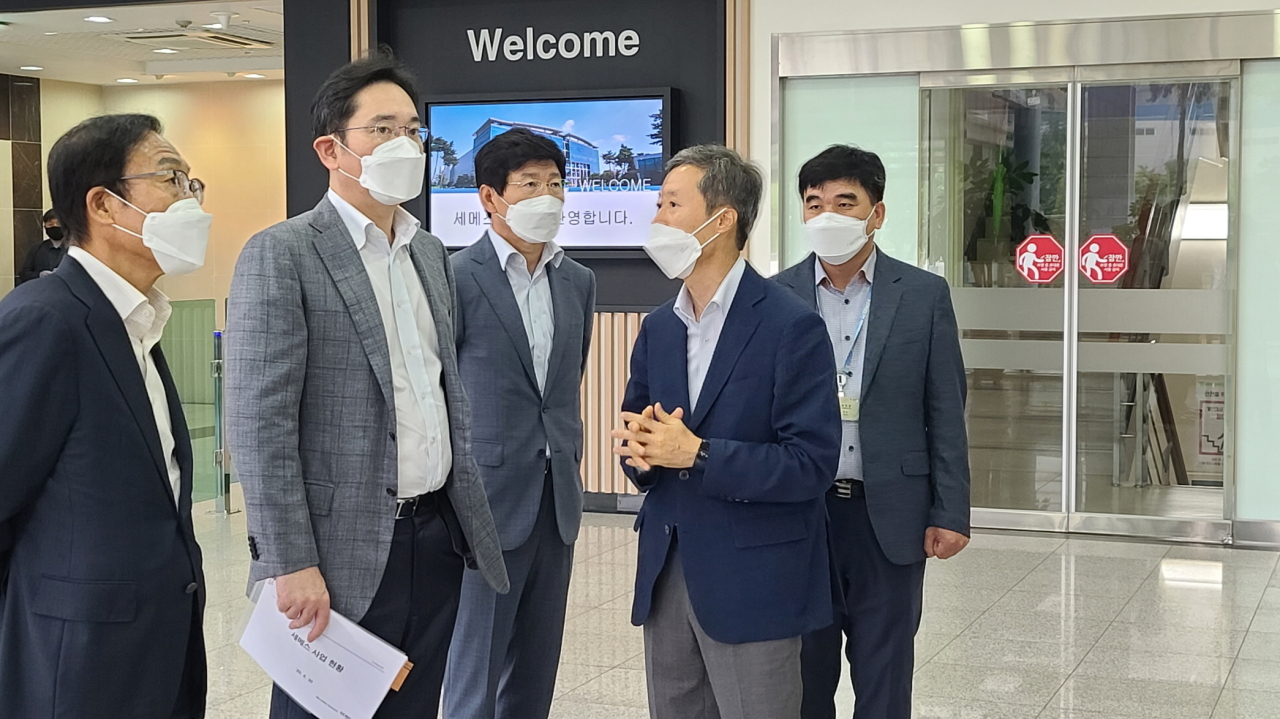 Samsung heir Lee Jae-yong (second from left) enters SEMES’ production line in Cheonan, South Chungcheong Province, on Tuesday. (Samsung Electronics)
