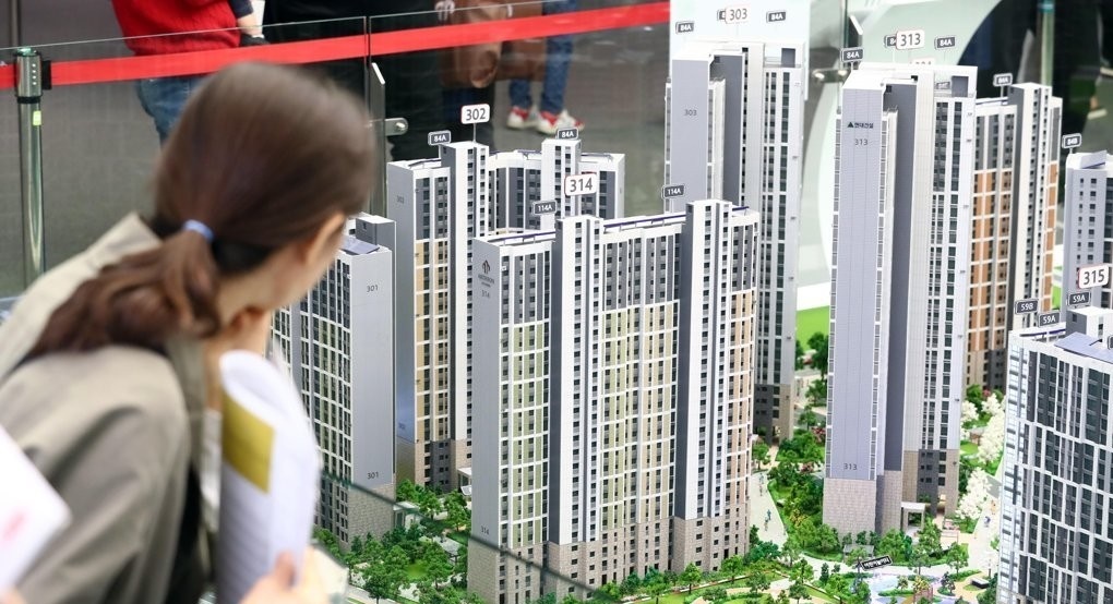 A visitor to a showroom for a new apartment complex looks at miniature apartments. (Yonhap)