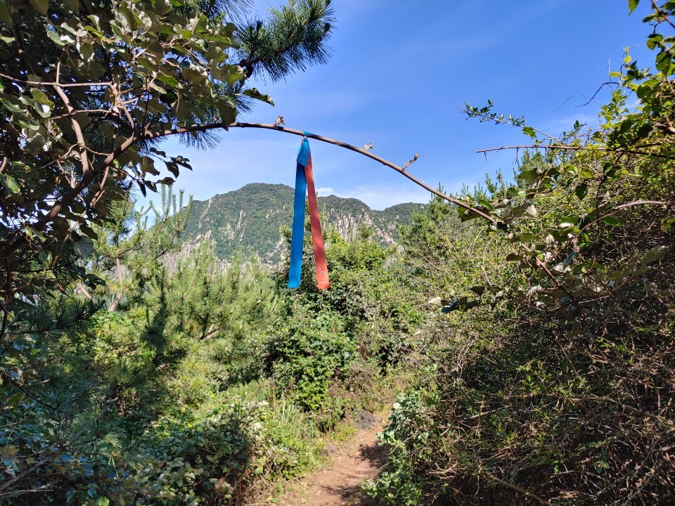 A ribbon marks an Olle path. Seen ahead is Sanbangsan on Olle Route 10. (Kim Hoo-ran/The Korea Herald)